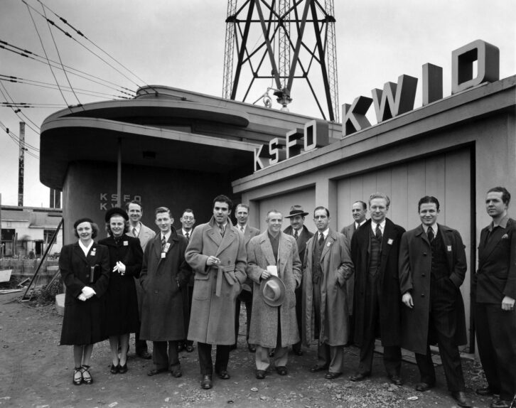 Shown in the black-and-white photo are staff members of KSFO in San Francisco, standing in front of the station’s brand-new transmitter plant, located on Islais Creek in the southeast part of the city.