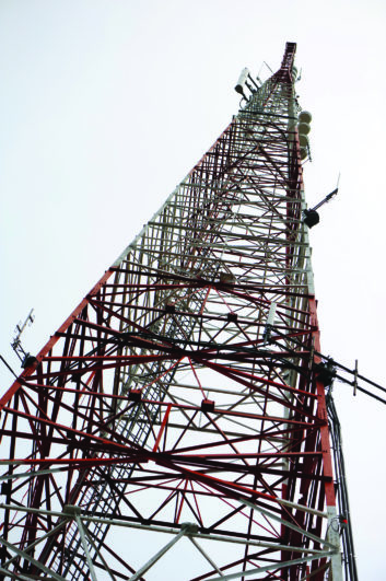 Shot looking up at tall telecommunication tower.