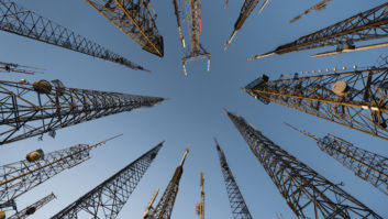 Photo looking up at several telecom towers