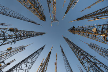 Photo looking up at several telecom towers