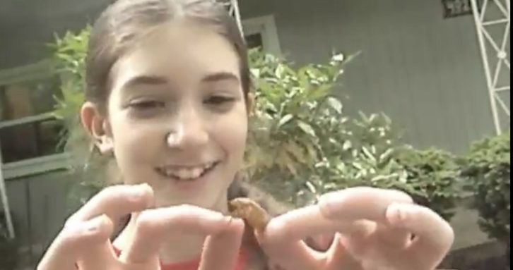 Girl plays with a cidada shell.