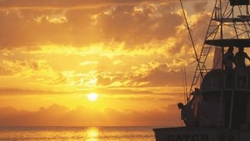 Image of a fishing boat against the sunrise