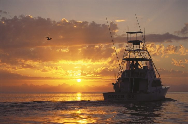 Image of a fishing boat against the sunrise