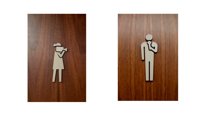 Bathroom signs with camerawoman and man with microphone