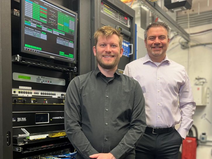 Andy Gunn and Rob Bertrand in front of equipment racks at WAMU