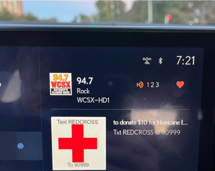 Quu visual metadata in a car dashboard displaying a message about the Beasley Media radiothon to support Red Cross efforts after Hurricane Ian