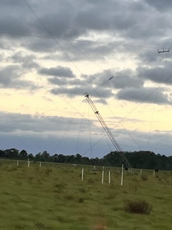 A broadcast antenna tower leaning badly after Hurricane Ian. It is part of a 44-degree rhomboid antenna that serves Europe.