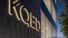 Exterior photo of KQED building at dusk with the call letters picked out by lights on the front. Photo by Jason O'Rear