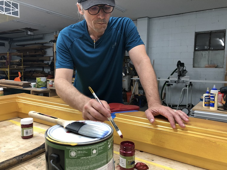 Sean Selby of WXOX paints custom woodwork.