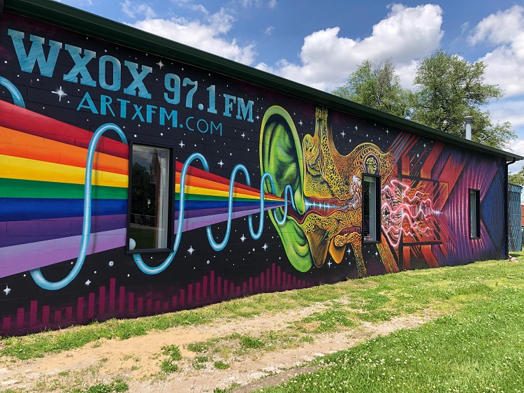 Brightly painted exterior of WXOX building with a rainbow-themed mural