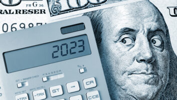 Concept image suggesting money and financial management, with a calculator and Ben Franklin's image from the money eyeing it warilly
