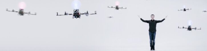 A photo of Marco Tempest surrounded by a swarm of media drones