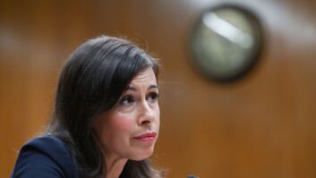 FCC Chairwoman Jessica Rosenworcel sits before a microphone and listens during a Senate Appropriations Subcommittee on Financial Servieces and General Government Hearing in Washington.