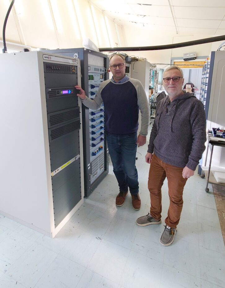 Guillaume Asso and Olivier Cordier stand with transmission equipment.