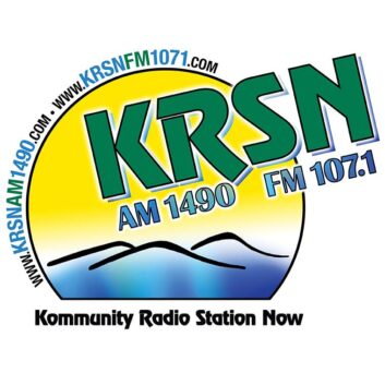 Logo of the former KRSN with the call letters in green over a cartoon image of mountains and sunshine