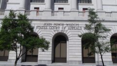 Front steps of a courthouse building, with a sign "John Minor Wisdom United States Court of Appeals Fifth Circuit"