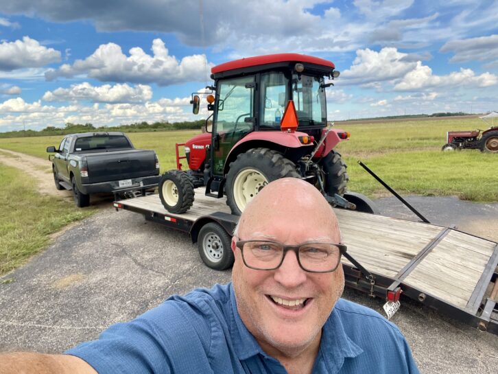 John Lackness uses two tractors to mow transmitter sites.