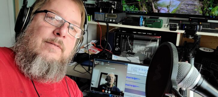 Gilles Letourneau is shown working from his remote studio, surrounded by radio gear. He became a co-host in 2017. Show creator Sheldon Harvey is on the screen.