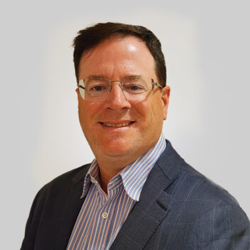 A man with a business jacket and open-collared business shirt