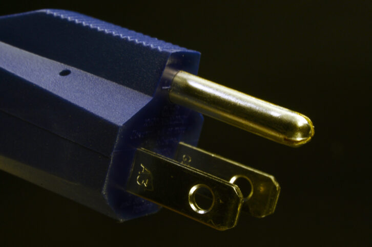 Close-up of a type B electrical plug. The type B plug (USA) has two flat parallel pins and one round ground pin.