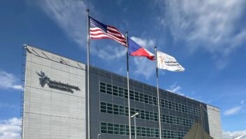 An office building with three flags in the front.