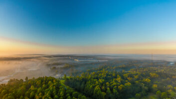 Aerial view of Southeastern Texas in a fog inversion with Autumn colored trees and a deep blue sky.