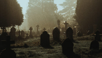 A spooky Victorian graveyard. With graves silhouetted by fog on a mysterious creepy winters night.
