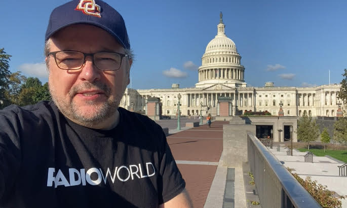 Paul McLane stands in front of the US Capitol's east face, wearing a DC hat and a Radio World T shirt