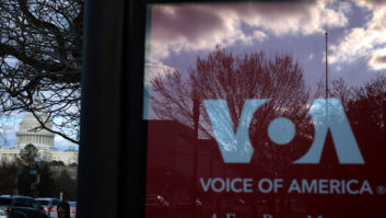 he U.S. Capitol is seen a Voice of America (VOA) sign on the glass window of a bus stop on March 17, 2025 in Washington, DC.