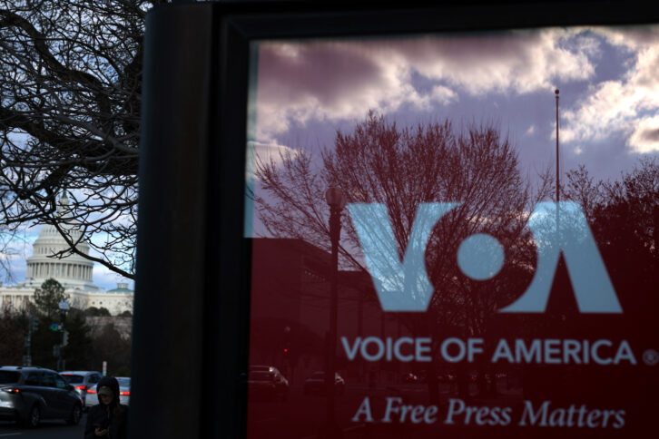 he U.S. Capitol is seen a Voice of America (VOA) sign on the glass window of a bus stop on March 17, 2025 in Washington, DC.