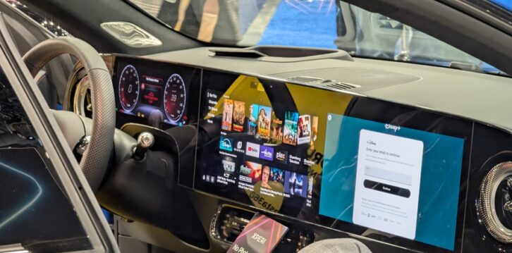 An interior view of the dashboard of a Mercedes-Benz CLA vehicle, with audio source icons as well as a large passenger-side screen
