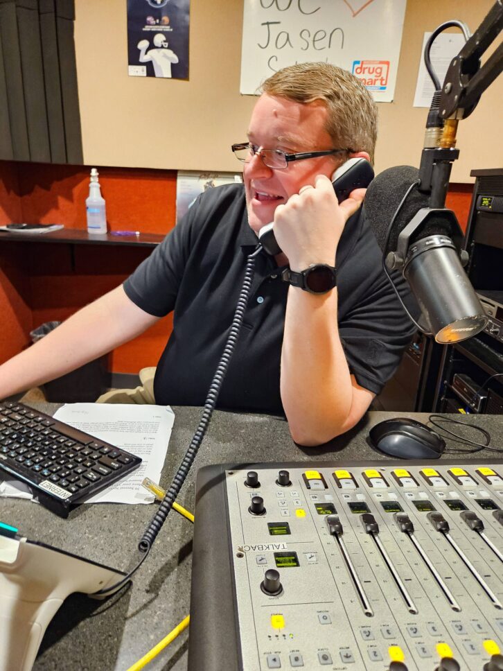 WJCU(FM) Director Jasen Sokol takes a call during its 2026 radiothon.