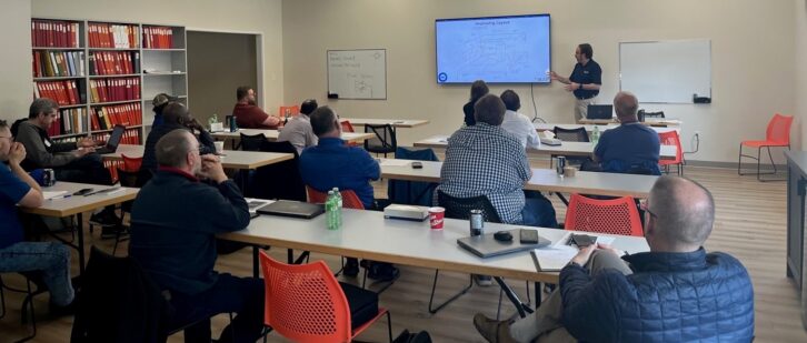 Engineers listen to a presentation in a classroom at Nautel