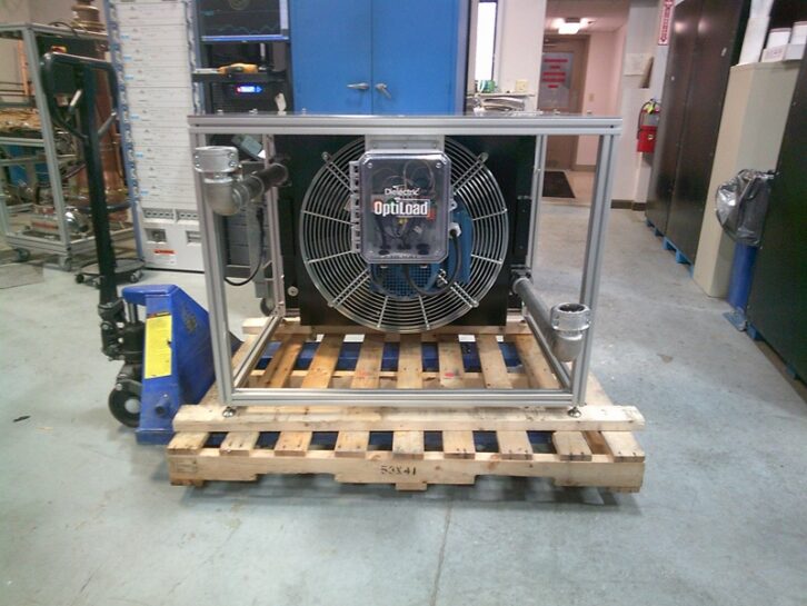 The Dielectric heat exchanger hardware is shown sitting on a pallet in a warehouse