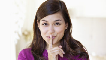 Portrait of a woman showing keep silence gesture