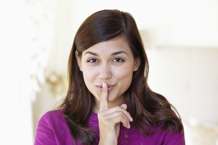 Portrait of a woman showing keep silence gesture