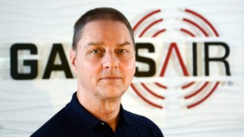 Russell Darrell stands in front of a GatesAir logo