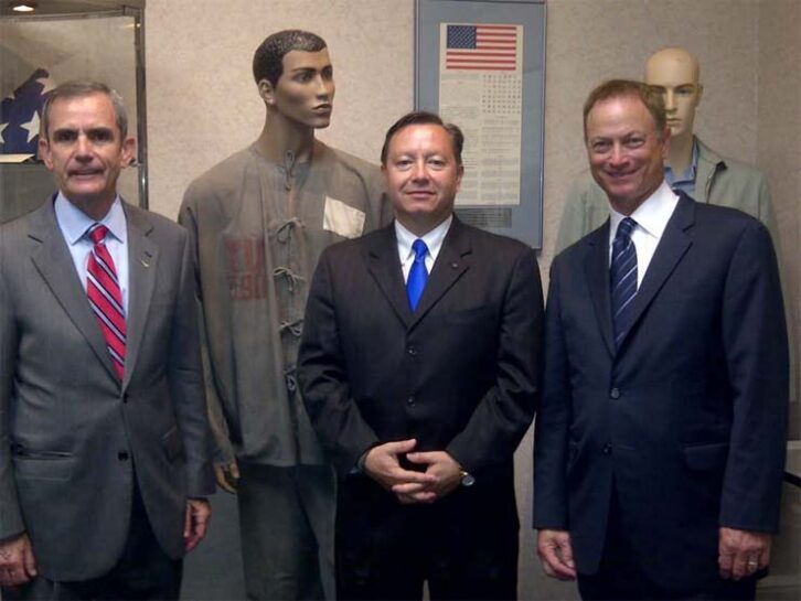 Ben Buehler-Garcia, center, poses with retired U.S. Air Force Col. Lee Ellis, left, who had been a prisoner of war in Vietnam, and actor/advocate Gary Sinise. They were at the POW Exhibit Hall at Randolph Air Force Base in San Antonio, Texas. Both have been show guests.