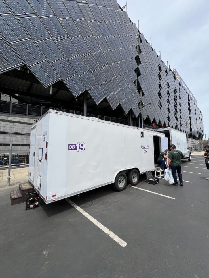 An outside broadcast vehicle deployed at Lincoln Financial Field in Philadelphia for the FIFA World Cup 2026. The setup integrates local RTS intercom systems with AEQ's Xpeak communications network to link production teams across multiple countries.