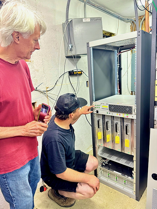 Ed Herrmann, standing, with Dylan Martin, install the new STX 10 FM transmitter for KOPN(FM).
