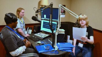 Student Ray Kinnie Mosley, Summer-in-the-Heights counselor Delaney Dalman and student Miles Anderson on the mic.