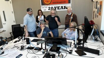 Staff members gather around the console in the WCOM studio