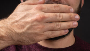 Close up portrait of scared young man covering with hand mouth