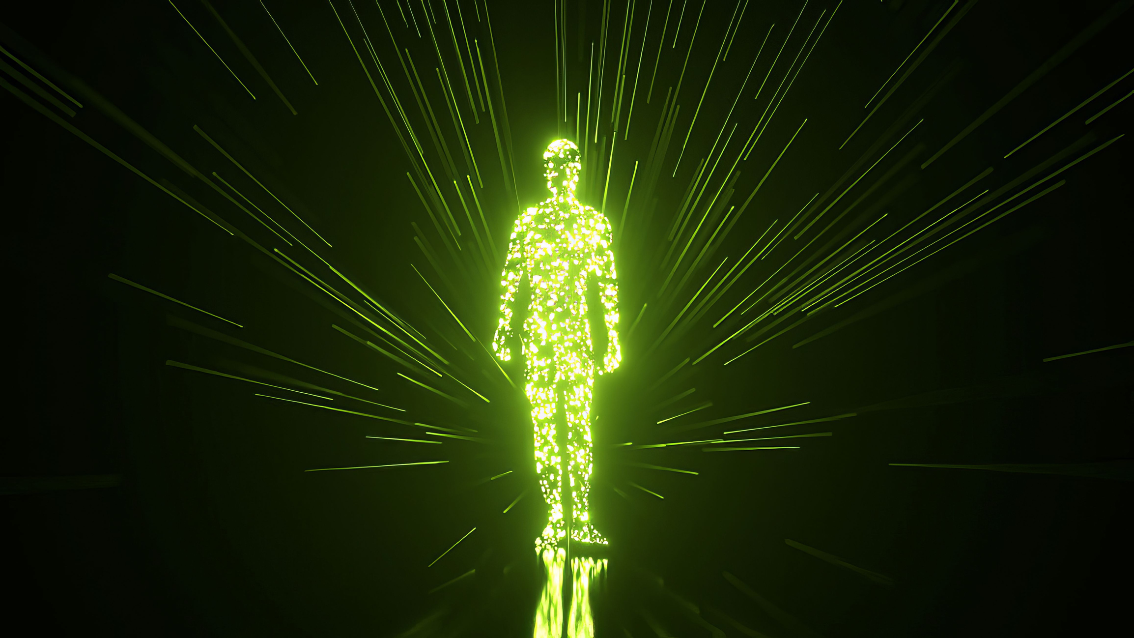 Green luminous particles coalesce to form a human silhouette, which stands while radiating brilliant light rays against a dark background, suggesting the power of people working with technology