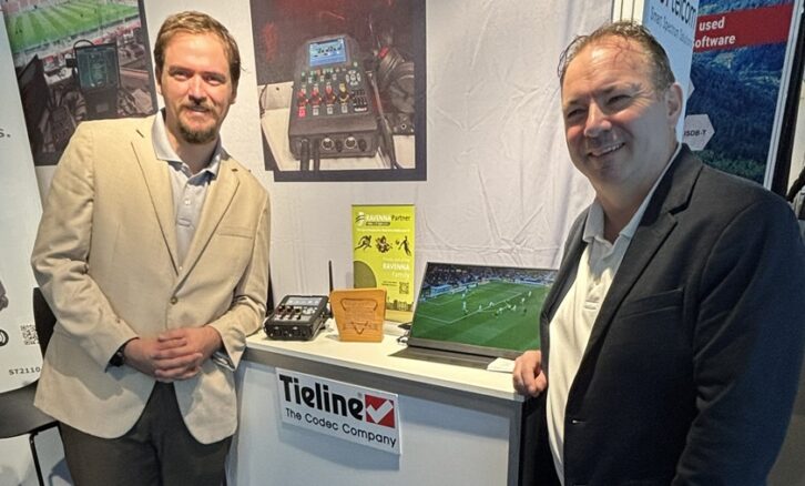 Two people stand in the Tieline booth
