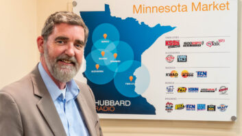 Bruce McKirdy with logos of the company’s Minnesota stations, including ones he manages in Brainerd and Bemidji.
