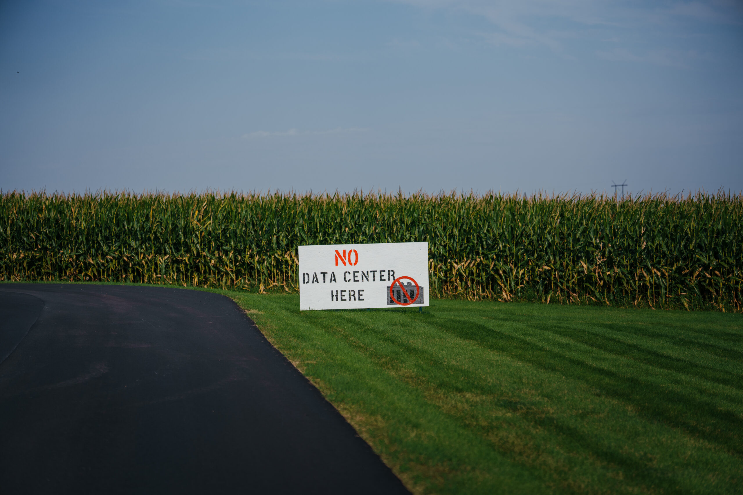 A 'No Data Center Here' sign at a cornfield near the proposed QTS data center site on the outskirts of Clinton, Iowa, on Wednesday, Sept. 2, 2026. Blackstone Inc.-owned QTS has a solution for the economic deficit of Clinton, Iowa: a massive data center that would bring thousands of construction jobs and provide nearly $200 million in property taxes in its first 10 years, a transformative sum for a place with a $25 million operating budget. Photographer: Jamie Kelter Davis/Bloomberg via Getty Images