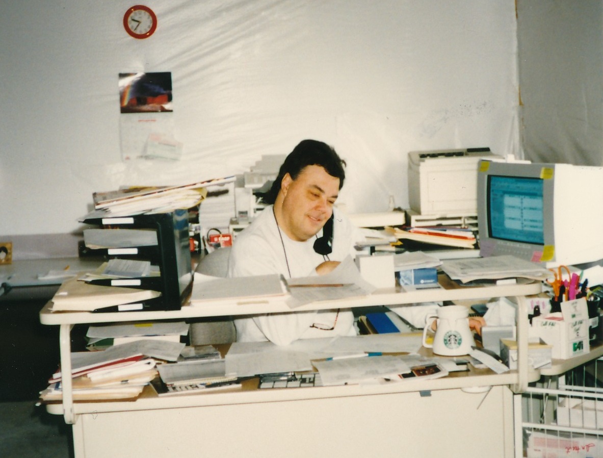 Don Winget is shown in an undated photo at a desk in a cluttered work area.
